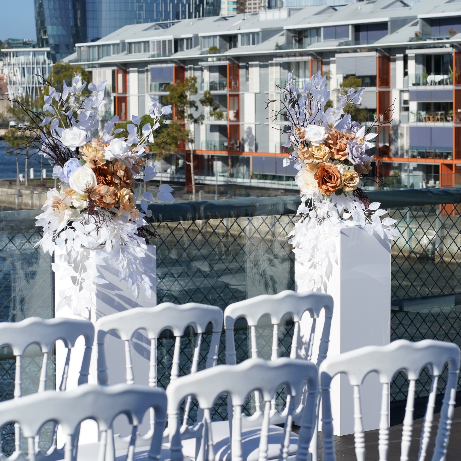 Elegant Wedding Ceremony Backdrop: Floral Arrangements on White Stands