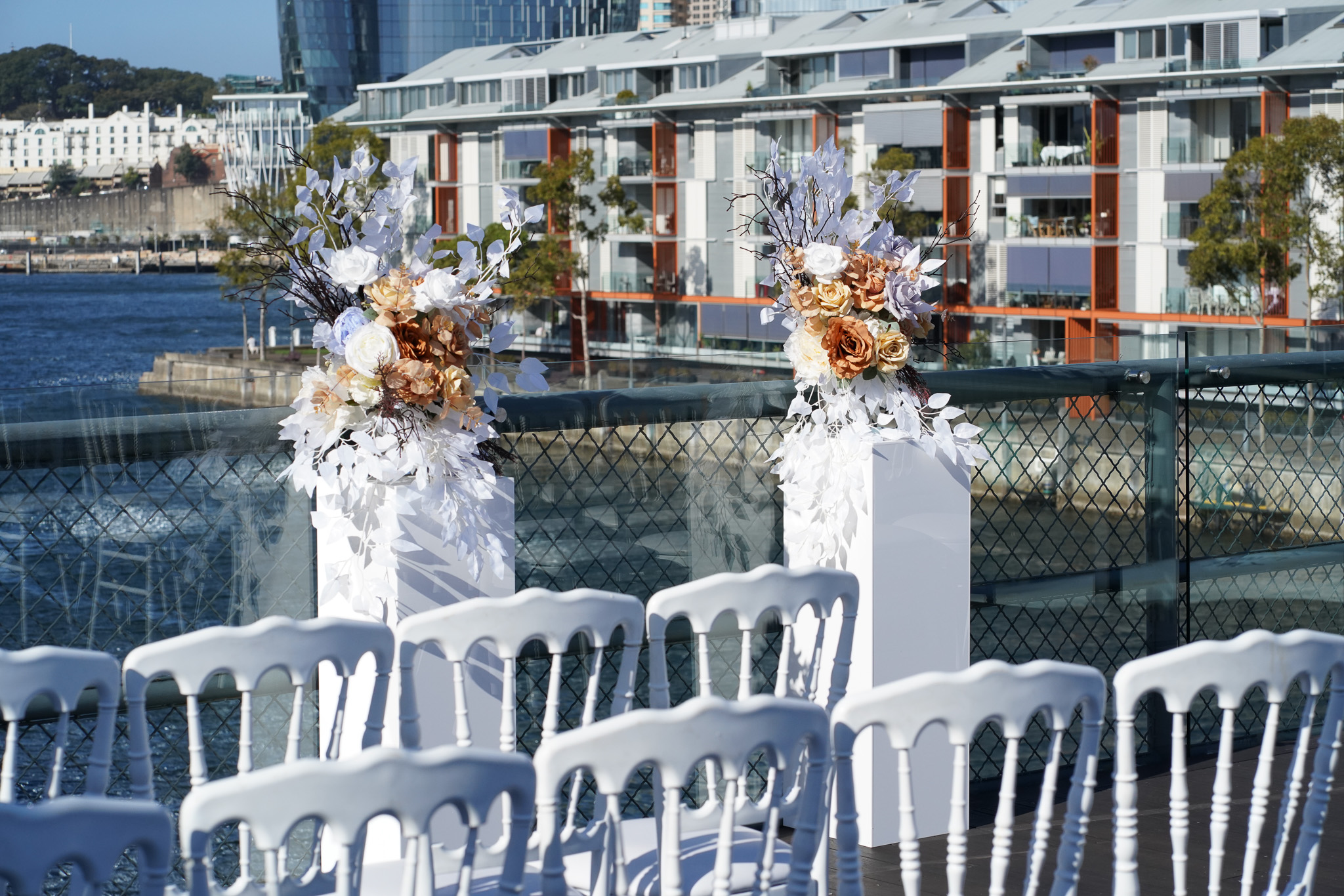 Elegant Wedding Ceremony Backdrop: Floral Arrangements on White Stands